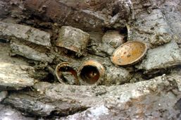 Kook- en eetgerei. Kook- en eetgerei naast de vuurkist uit zestiende-eeuws scheepswrak L 1 opgegraven in 1990 in het midden van Zuidelijk Flevoland.
