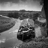 Start van de suikerbietencampagne, 1951. De reis van schipper S. Meter van de <em>Twee gezusters</em> (40 ton) met de eerste suikerbieten van het seizoen vanuit Friesland naar de suikerfabriek in Groningen begon niet fortuinlijk. Zijn kleine volgeladen vaartuig kon slechts met de grootste moeite door een smalle, ondiepe, slecht onderhouden bocht komen. Zijn schip werd voortgetrokken door een opduwer, die in dit geval dienst deed als sleepbootje. Twintig jaar later was dit vervoer overgenomen door vrachtauto’s.