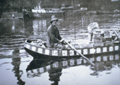 Parlevinker met zijn scheepje bij Alphen aan den Rijn, circa 1930. Parlevinkers waren ondernemers die met hun vaartuig bij schippers langs voer om hun goederen, meestal levensmiddelen of brandstof, te verkopen. Het beroep is thans nagenoeg uitgestorven.