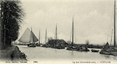 Zeilend vrachtschip ontmoet een sleep op het Merwedekanaal bij Jutphaas, circa 1900. De sleep telt tenminste vijf zeilschepen en vaart tegen de wind in. Het zeilschip vaart met volle zeilen voor de wind. Uit de foto blijkt dat er op het drukke Merwedekanaal bij tegenwind voor zeilschepen onvoldoende ruimte overbleef om tegen de wind op te laveren. Ze moesten zich dan laten slepen.