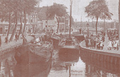 Kruip door sluip door op het Franekereind in Harlingen, circa 1909. Het krappe Franekereind was tot ver in de twintigste eeuw één van de hoofdroutes voor het binnenvaartvervoer naar Groningen en Friesland.