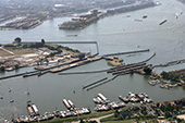 Oranjesluizen en Prins Willem-Alexandersluis bij Amsterdam, 2006. Dit sluizencomplex vormt de verbinding tussen enerzijds het IJ en het Amsterdam-Rijnkanaal en anderzijds het IJmeer. De Oranjesluizen waren aanvankelijk een onderdeel van het Noordzeekanaal en kwamen in 1872 in bedrijf. Omdat ze te krap werden voor het moderne binnenvaartverkeer, werd het sluizencomplex in 1995 uitgebreid met een vierde schutkolk, de Prins Willem-Alexandersluis, die voldoende ruimte biedt voor vierbaksduwstellen. Rechts de drie schutkolken van de Oranjesluizen en links de Prins Willem-Alexandersluis.